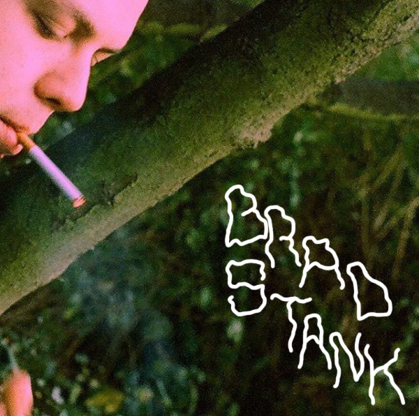 Brad Stank smokes a cigarette in the upper-left-hand corner of the photo. The words “Brad Stank” appear in the opposite corner of Stank.