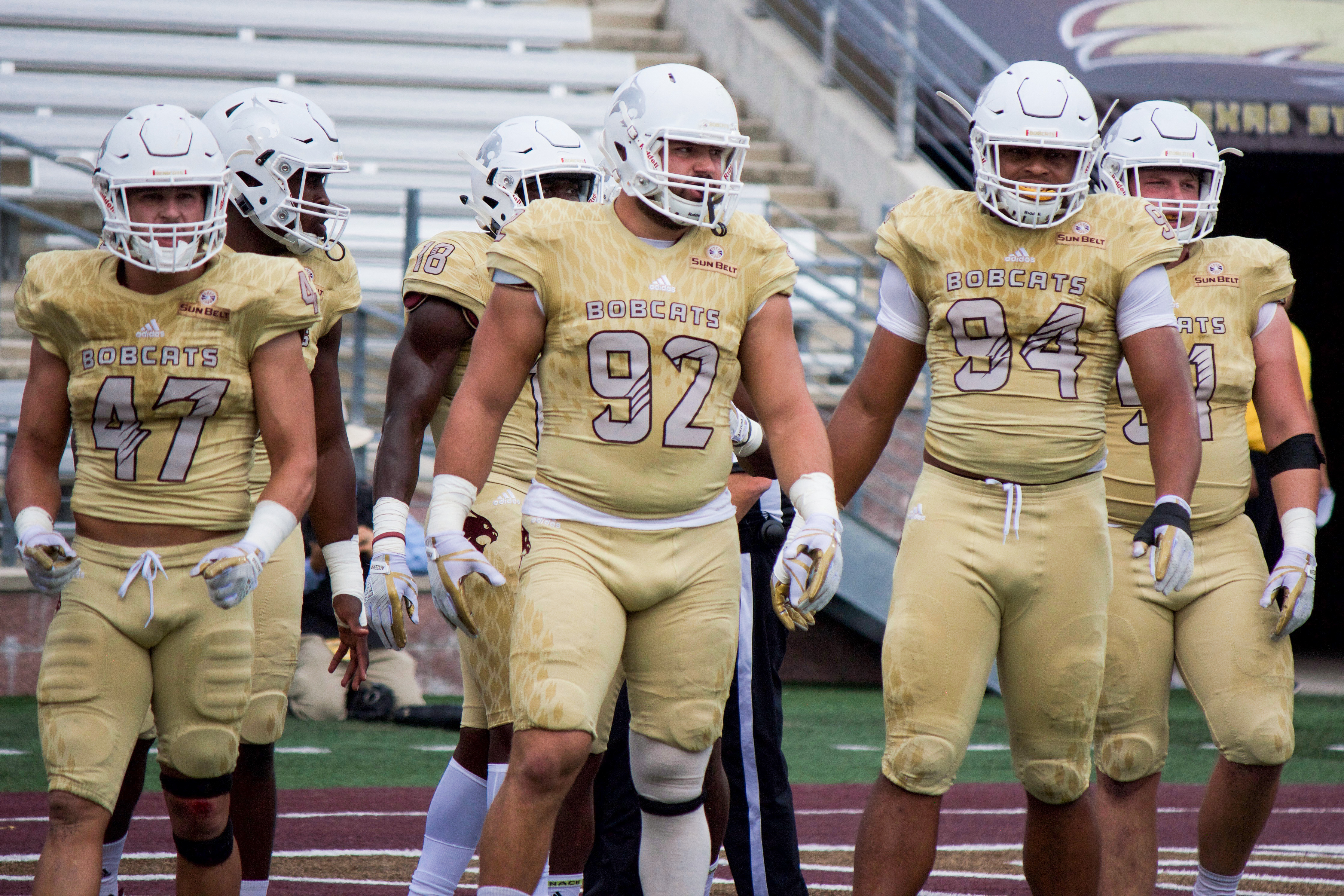 In golden uniforms, from left to right, number 47 A.J. Krawczyk, number 92 Grant Lanza, and number 94 Dean Taylor prepare to command the gridiron against ULM in the 2017 matchup. The defensive front will be seeking better results this season after losing 45-27 to the tune of a finesse, spread offense last season