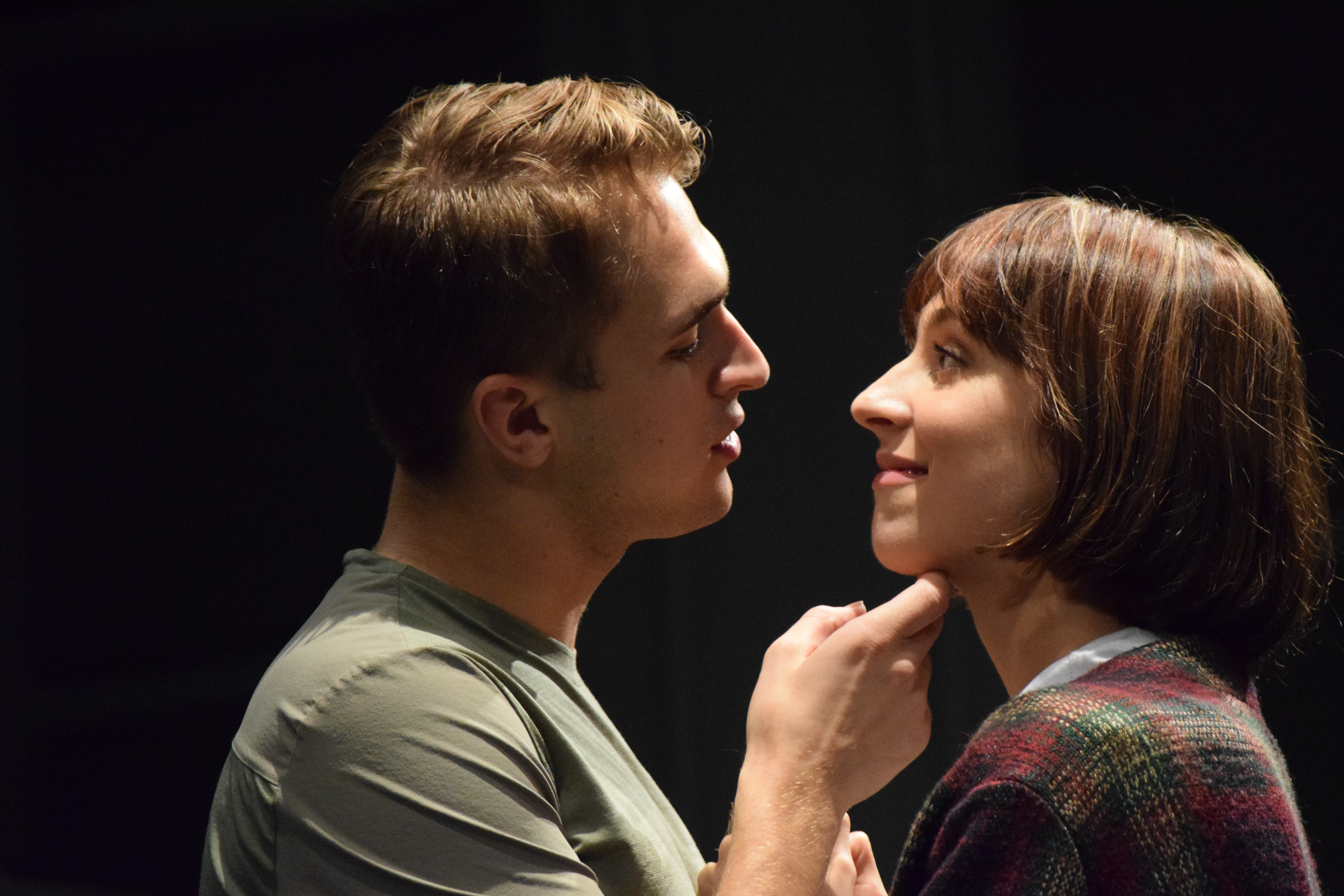 Jacob Burns cradles Logan Rae's face in rehearsal.