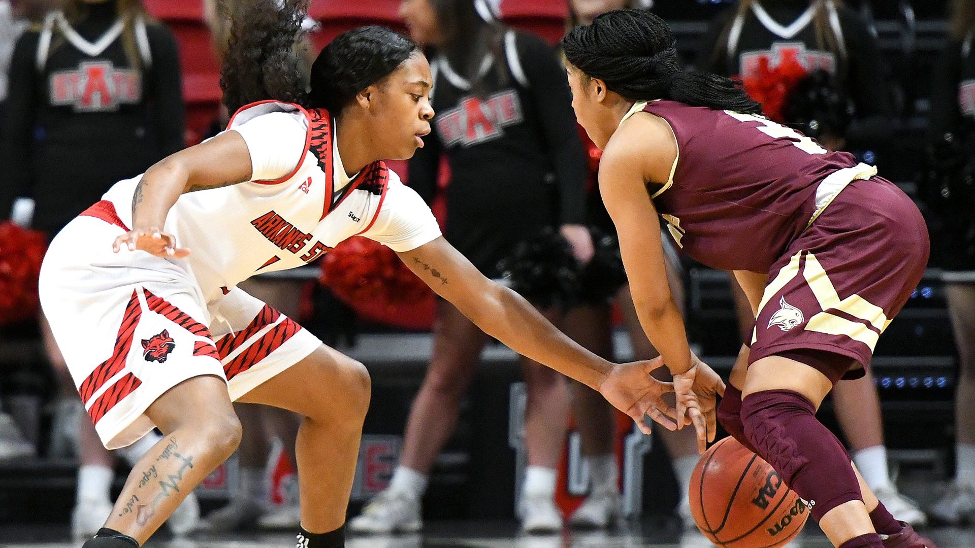 A Texas State player keeps the ball from an Arkansas State player.
