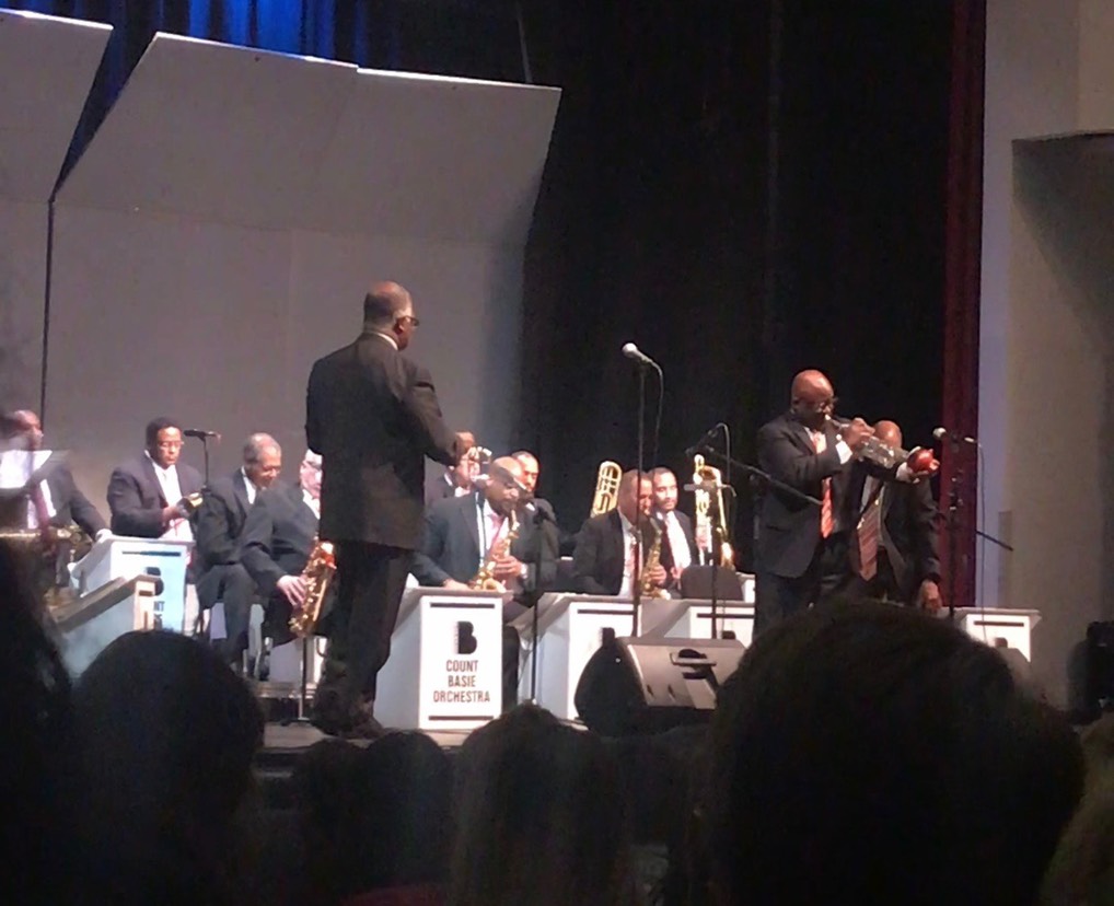 Member of the count basie orchestra performing a trumpet solo on stage