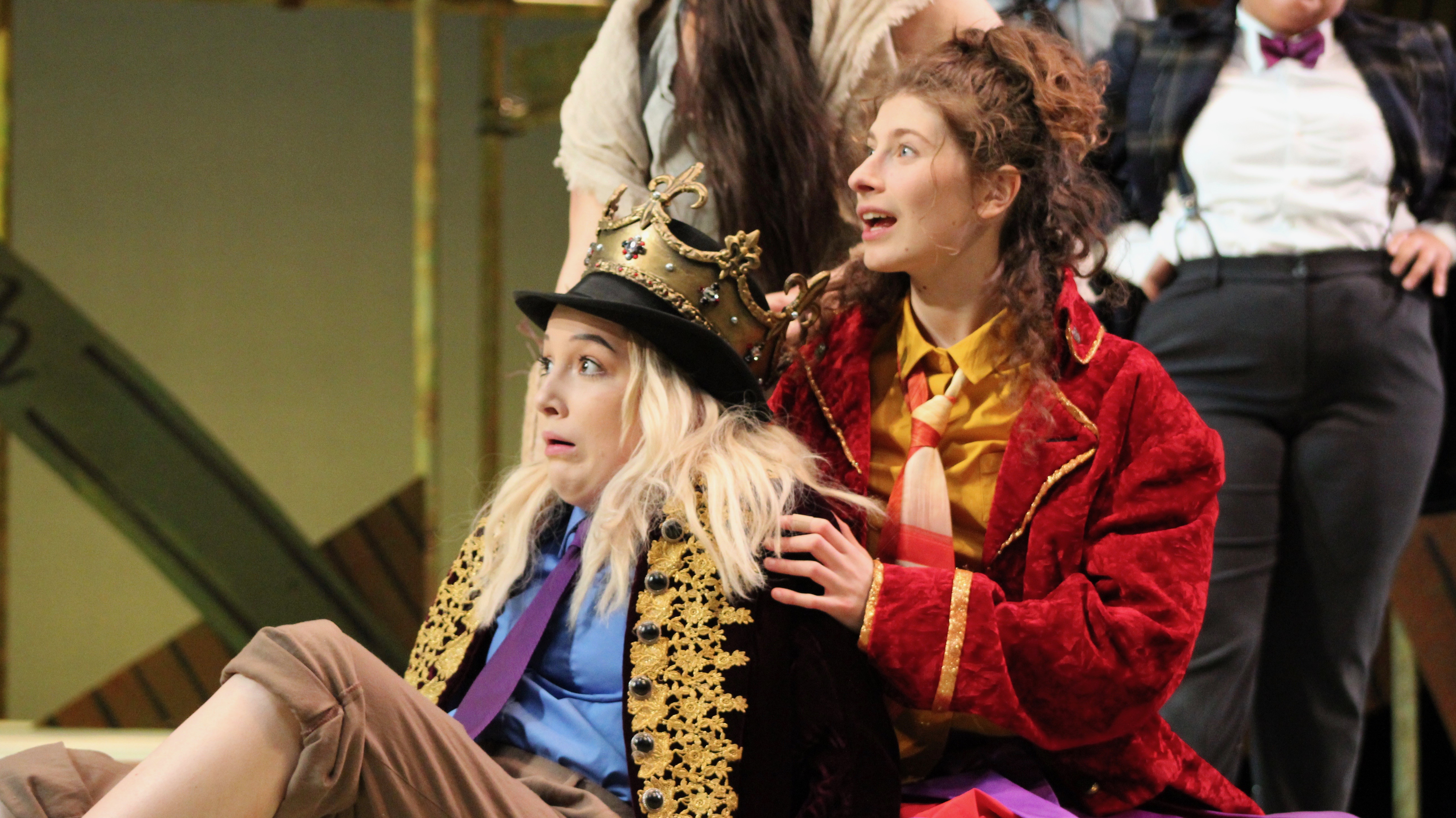 Two girls, one brunette and one blonde, in royal livery.