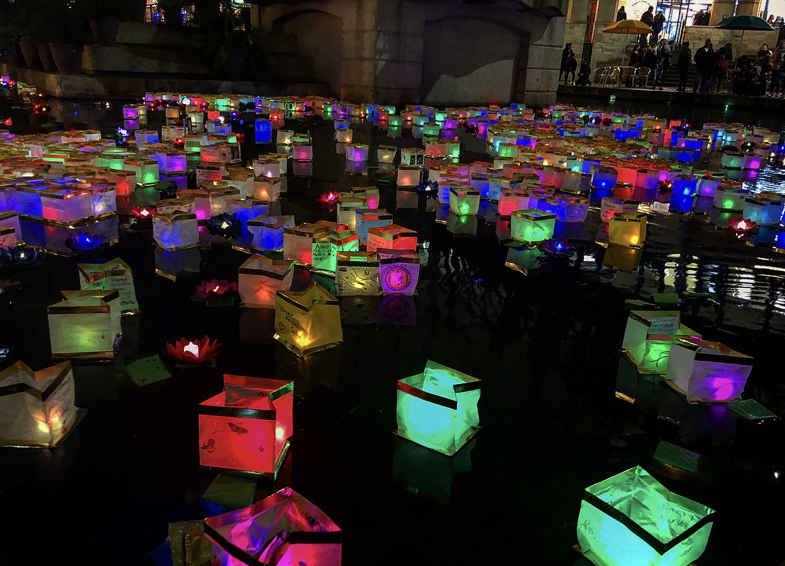 Hundreds of lit lanterns of various bright colors fill the San Antonio River.