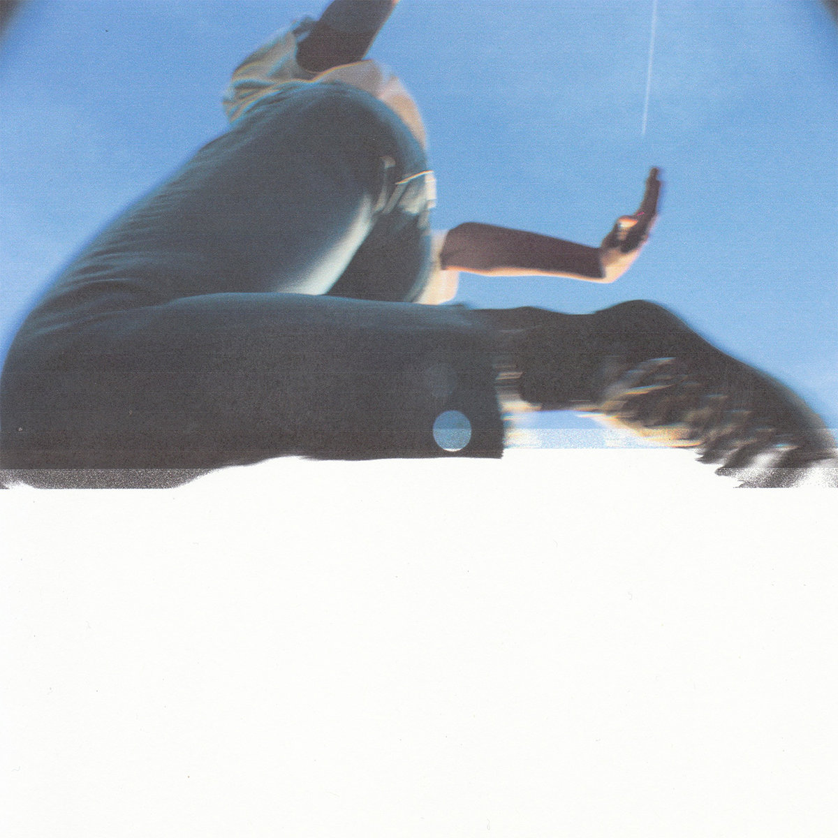 The album cover is a blurry image of someone wearing blue jeans jumping over the camera.