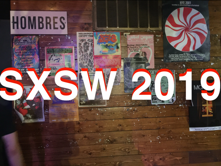 colorful band posters for SXSW 2019 on wall of venue