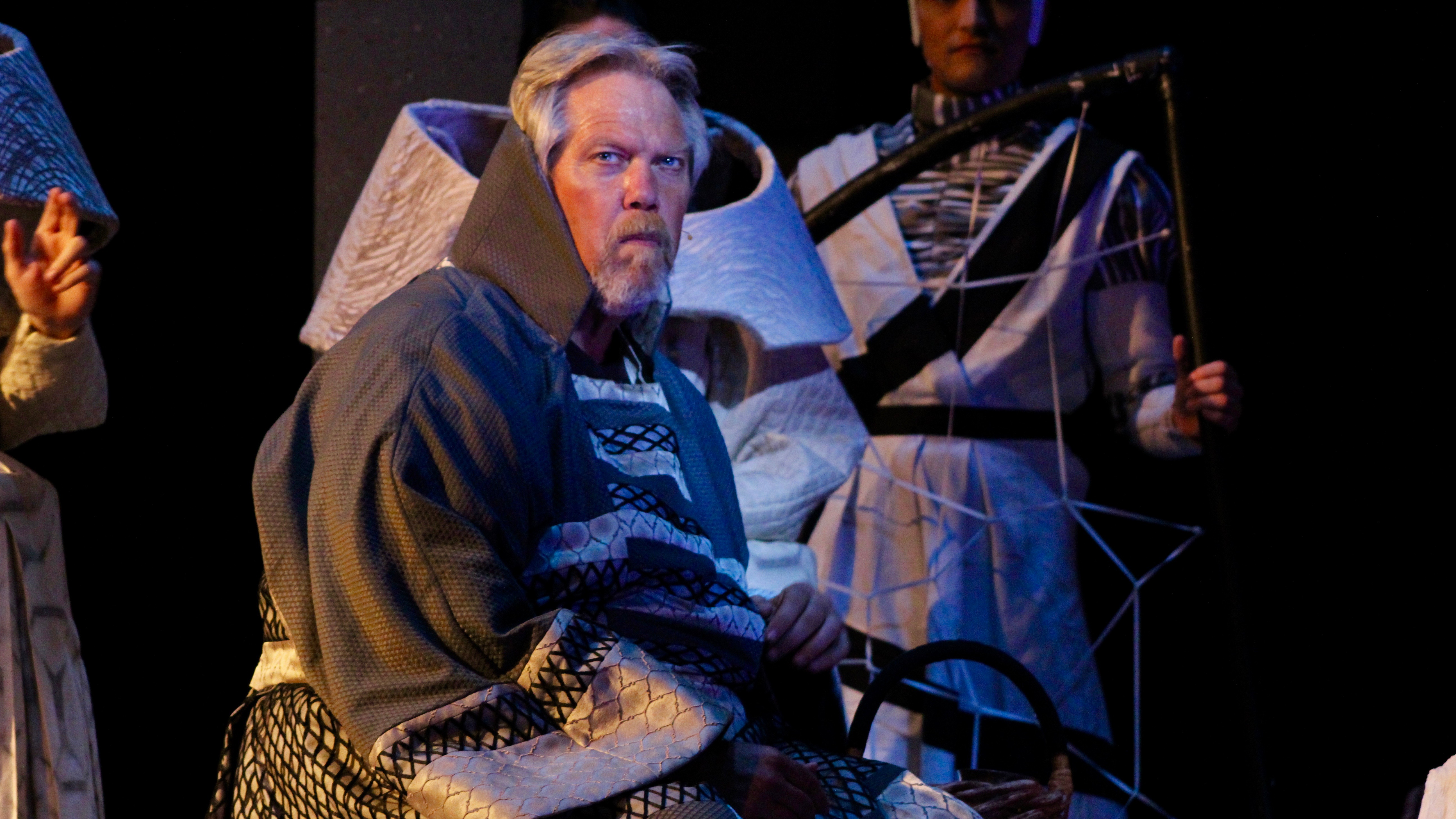 Man in robes stares at audience during a rehearsal for the Hunchback of Notre Dame.