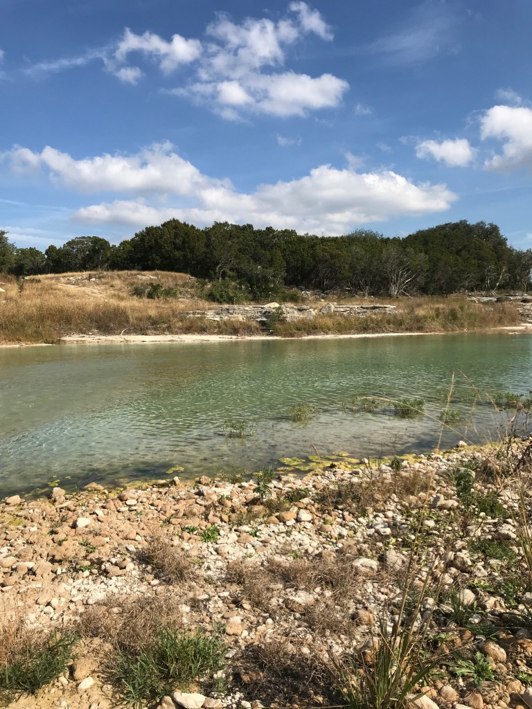 a view of the blue Blanco River from the other side