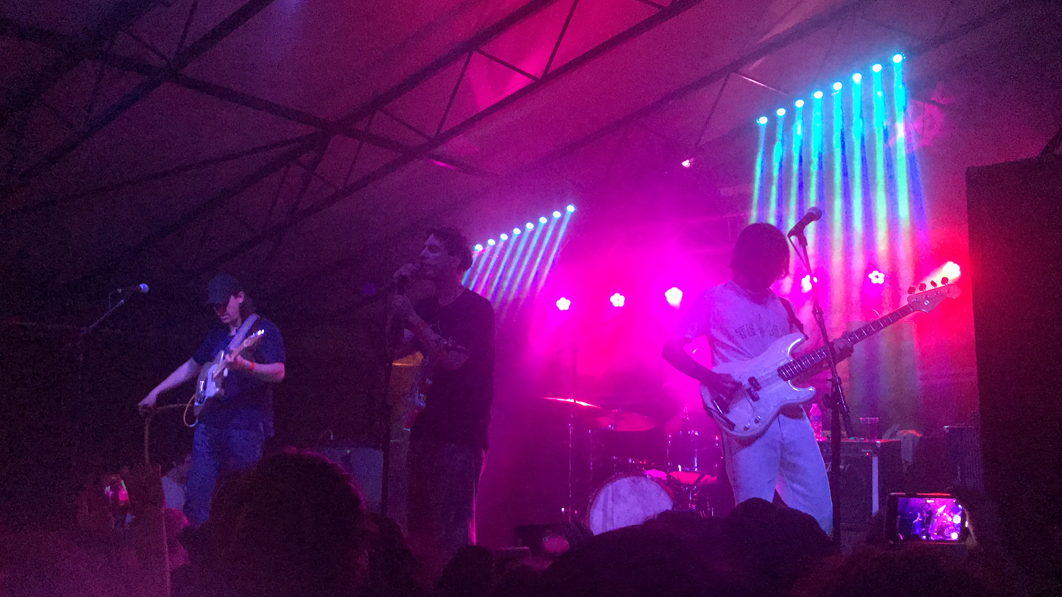 Three people playing guitars and bass.