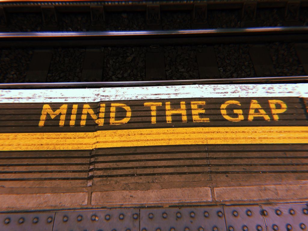 A photo of London’s iconic “mind the gap” floor writing in the underground tube station.