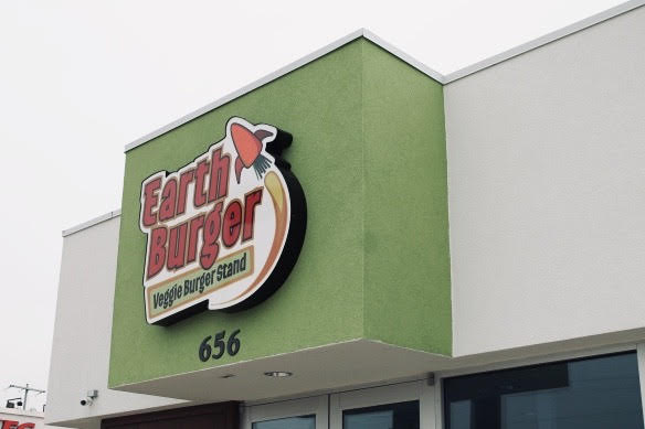 The Earth Burger logo on a green building