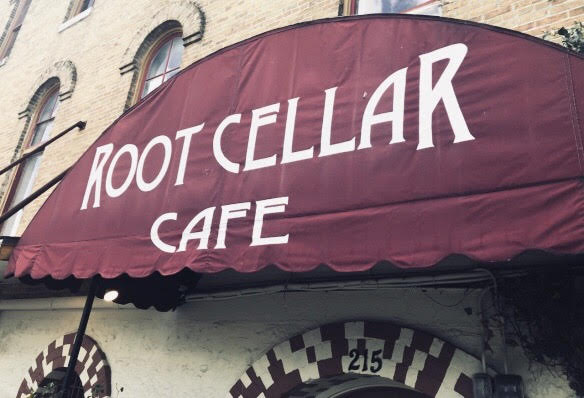 Root Cellar Cafe in white lettering on a red canopy outside the restaurant