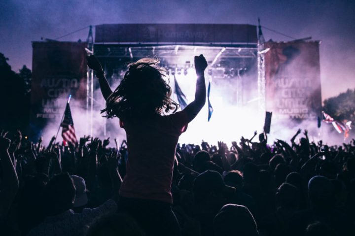 Photo from the crowd at an Austin City Limits Music Festival with people on each others shoulders.