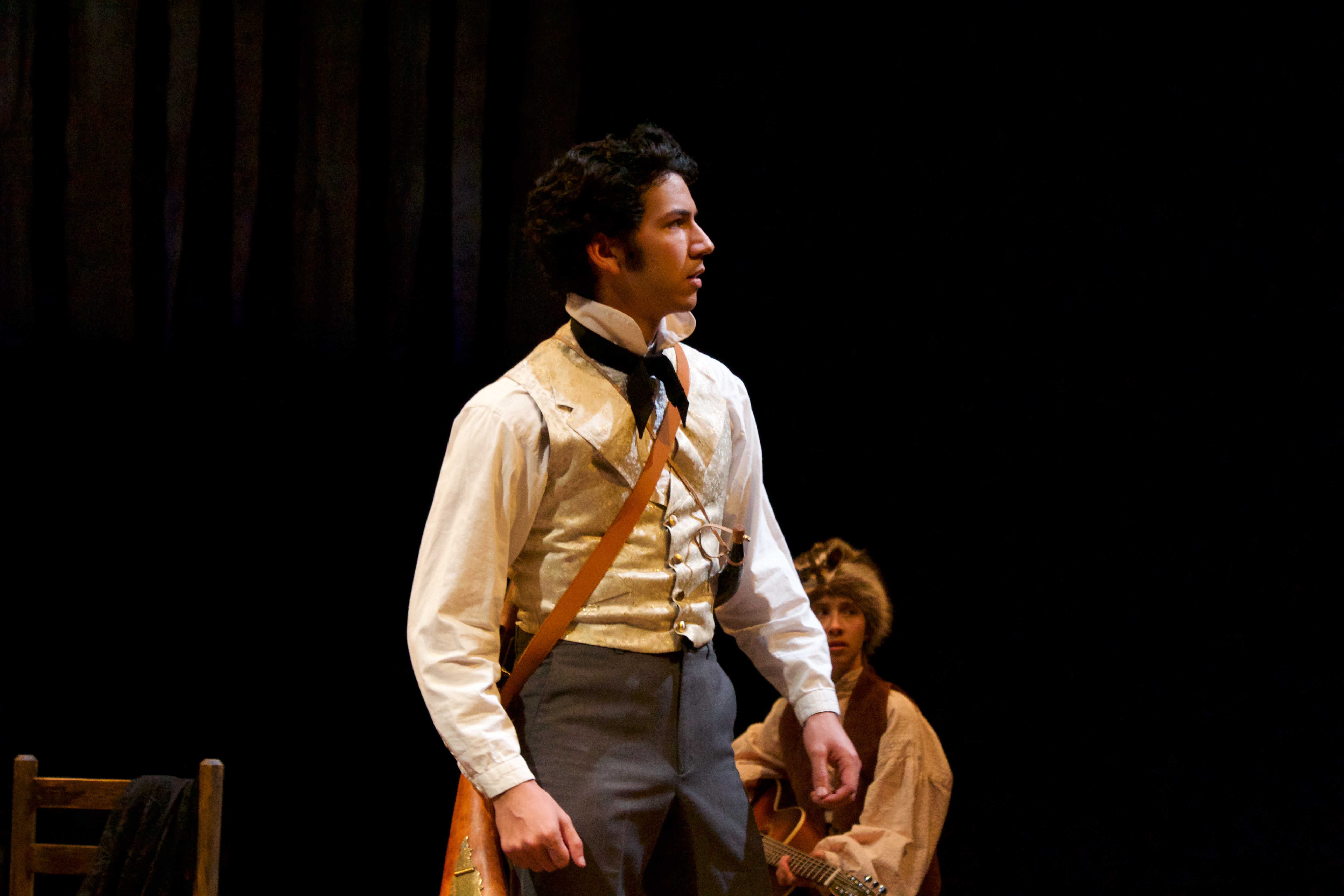 Man in period costume with a rifle across his torso.