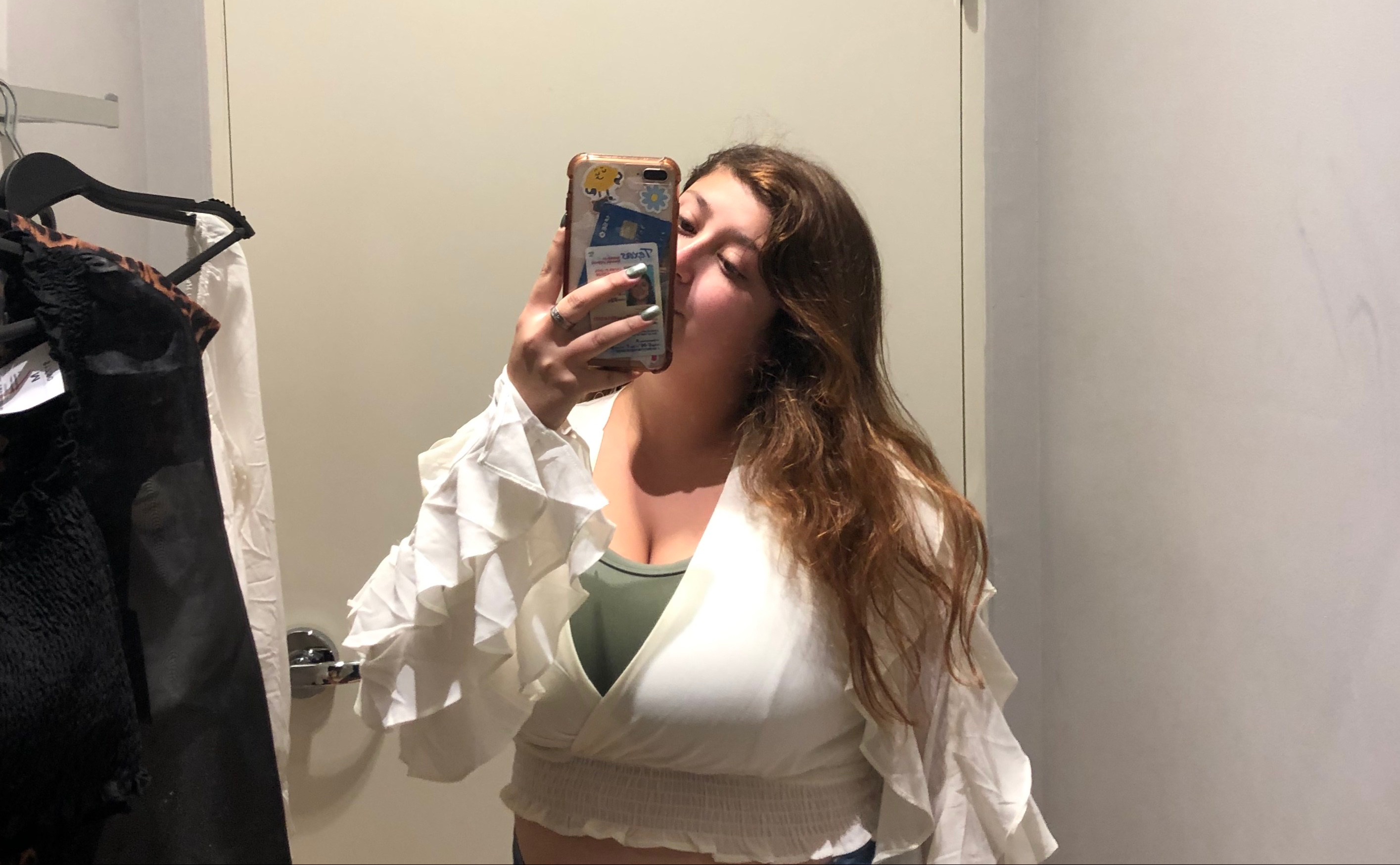 This is a picture of me in the dressing room wearing a white flowy sleeved shirt in the Forever 21 dressing room.