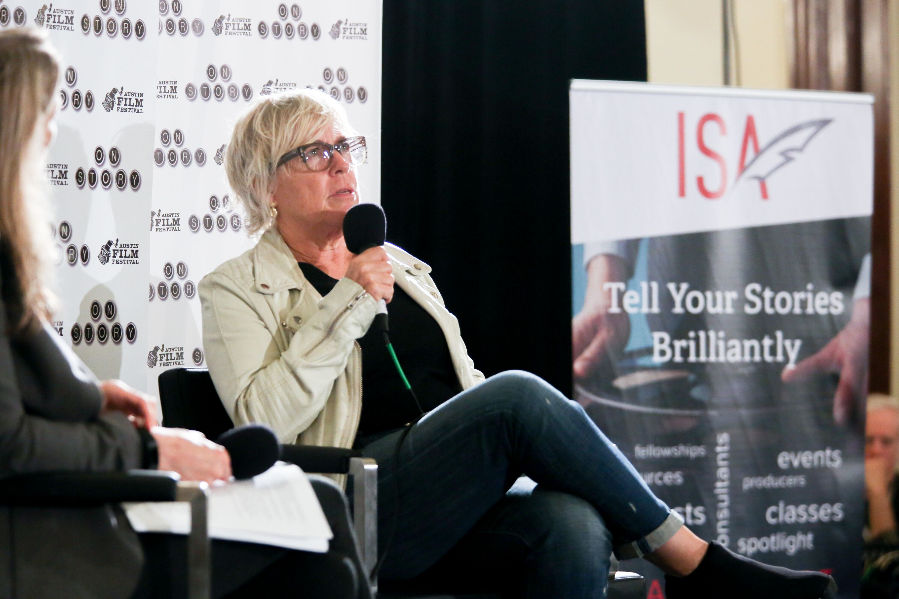 Two women on stage holding microphones