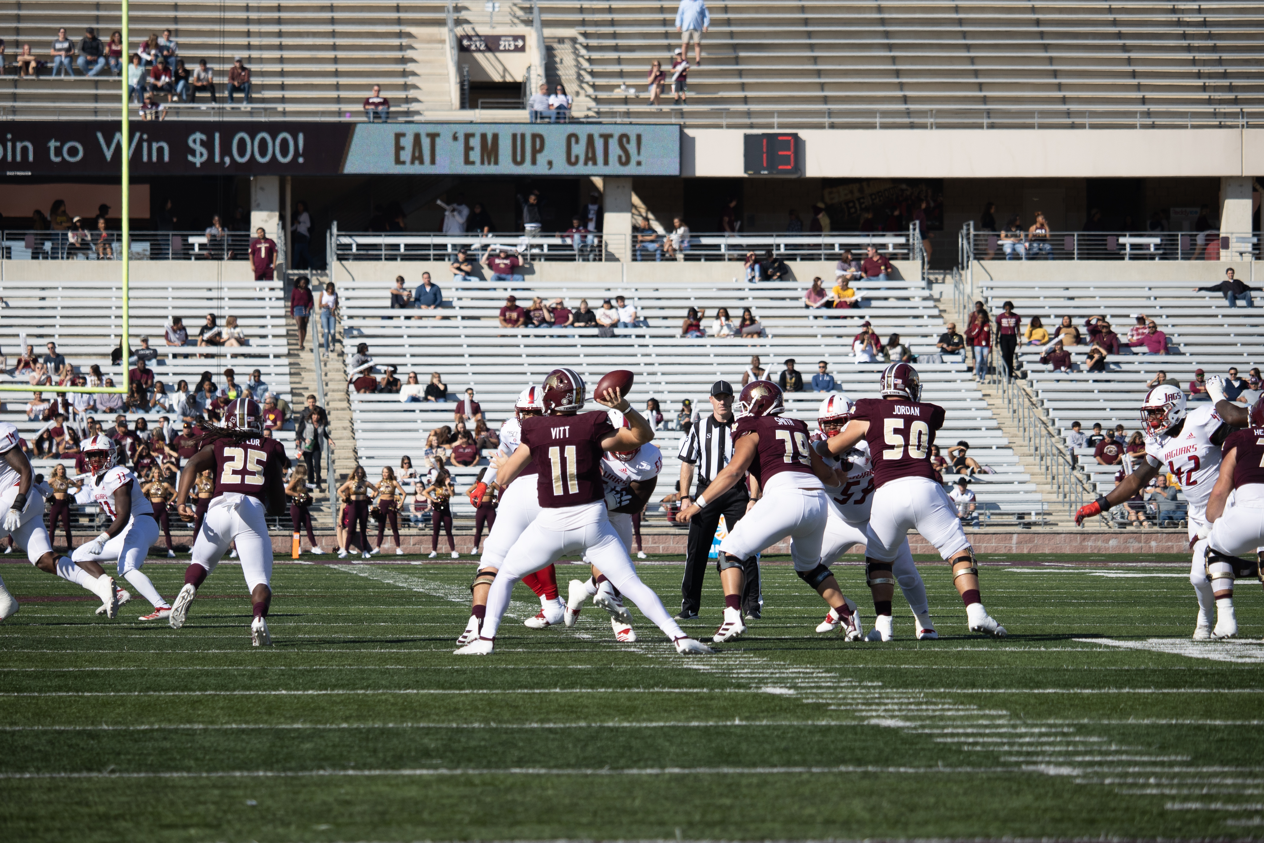 Quarterback Tyler Vitt is throwing the football off to the left behind his offensive line.