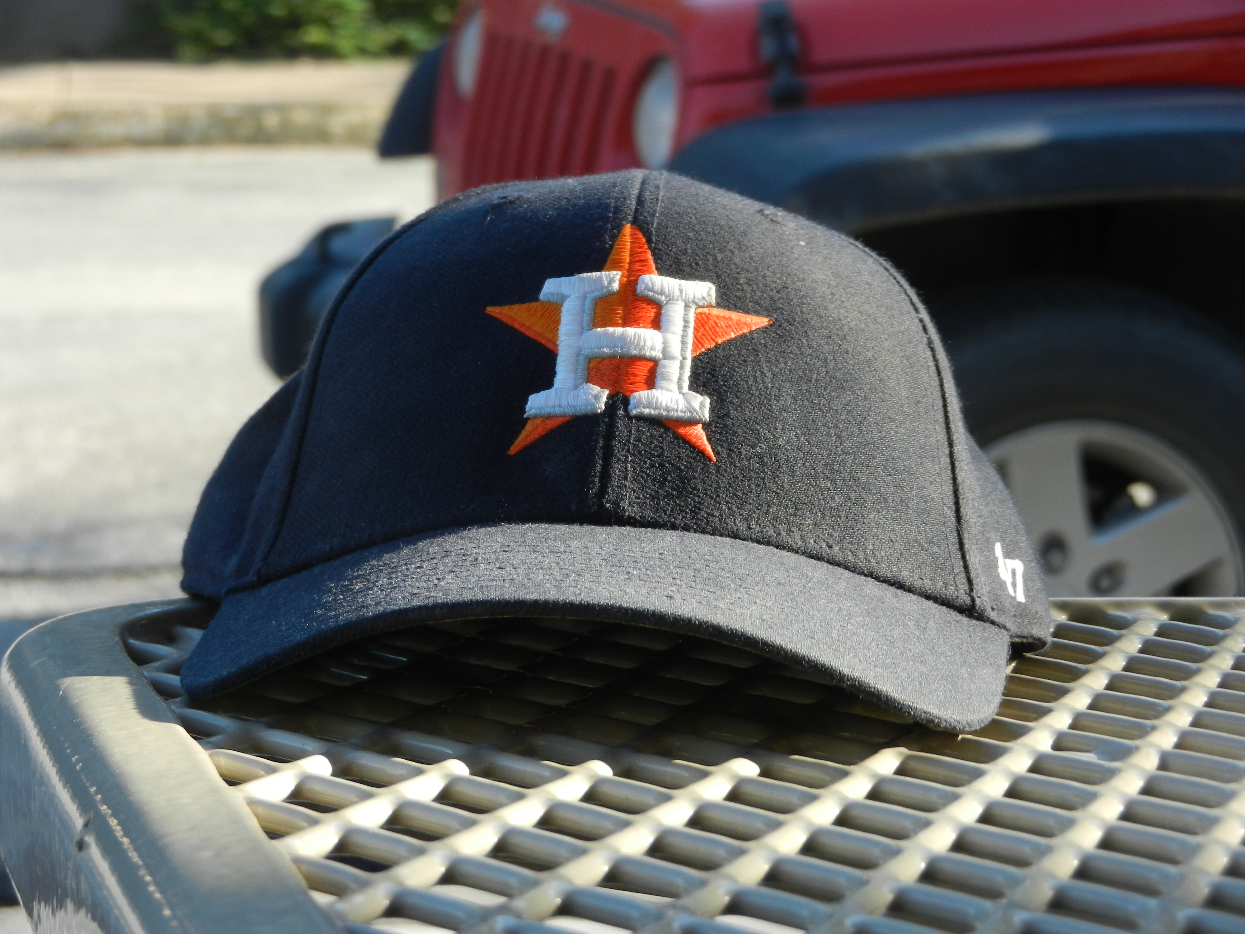 An Astros cap sits at the edge of a picnic table.