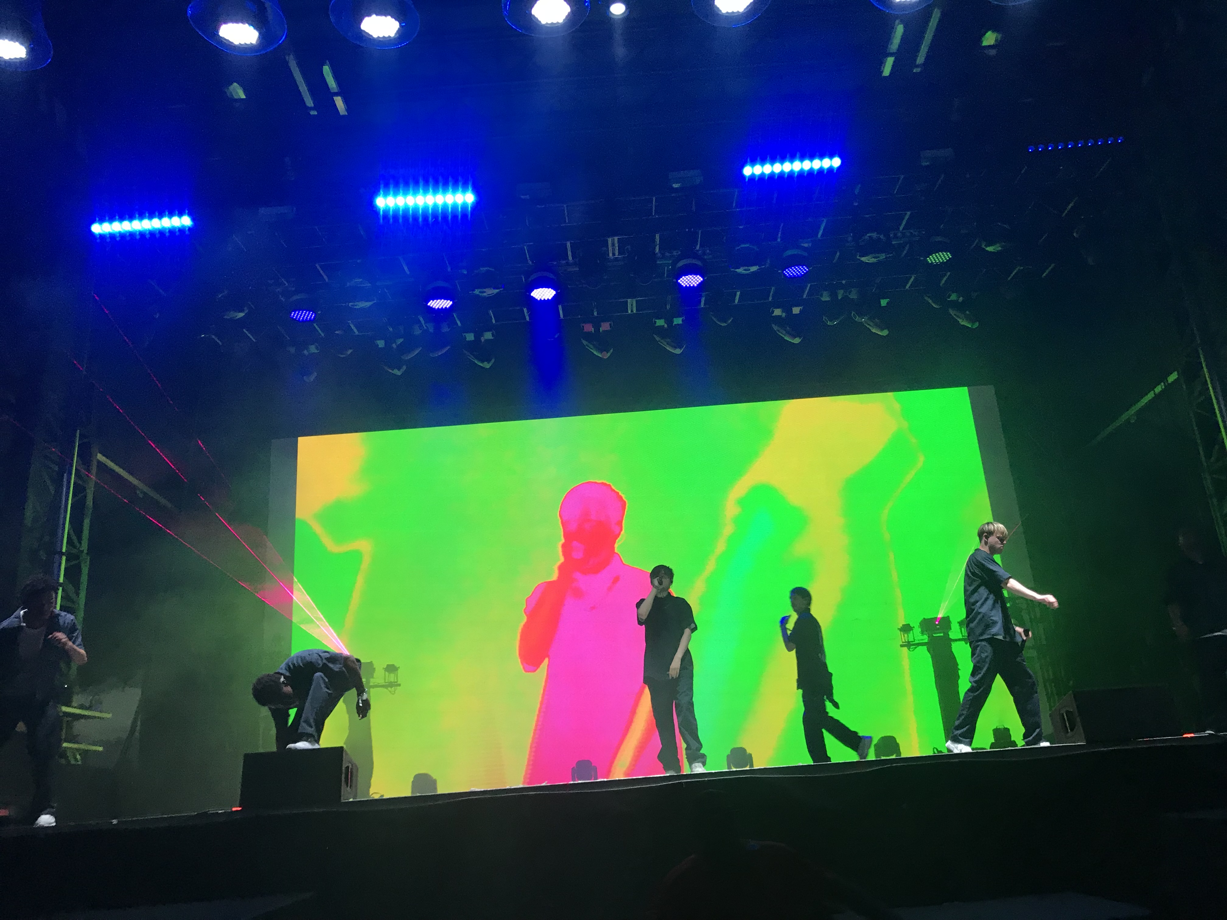 Five men performing on a colorful lit up stage