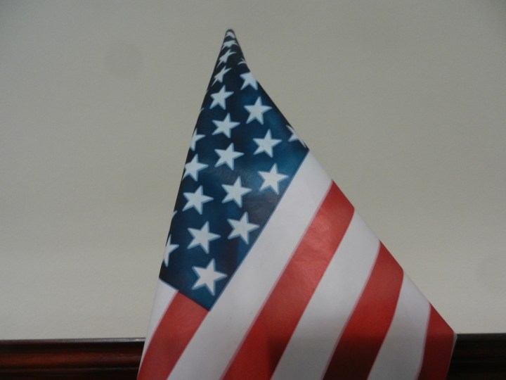 An American flag proudly hangs from a bookshelf.