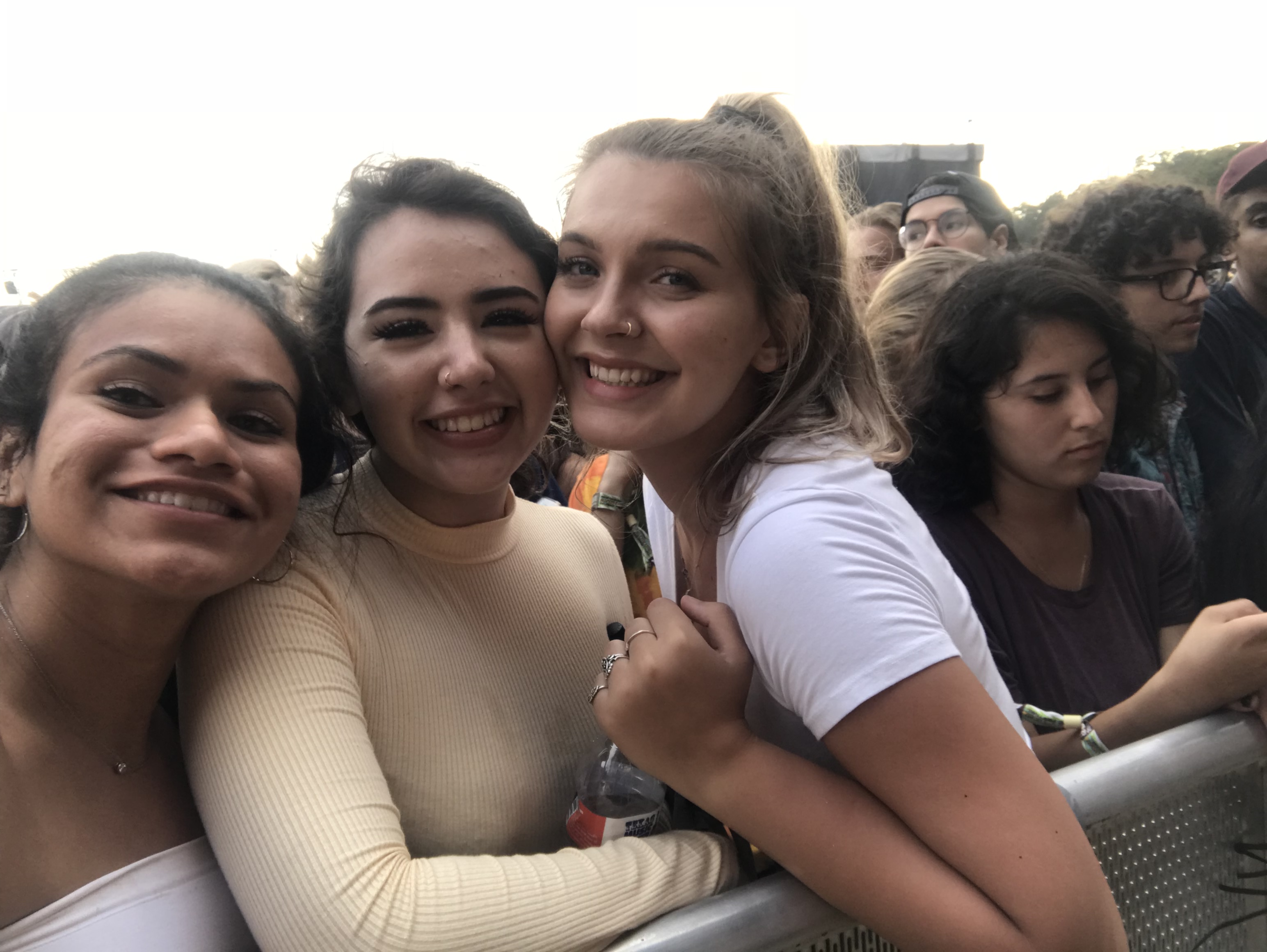 three girls pose in front of a crowd