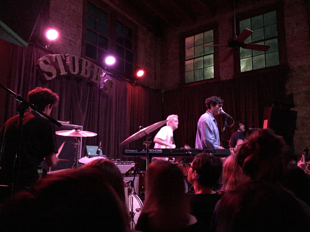 You can see the four boys on stage. The Stubbs logo behind them as they play beneath the stage lights.