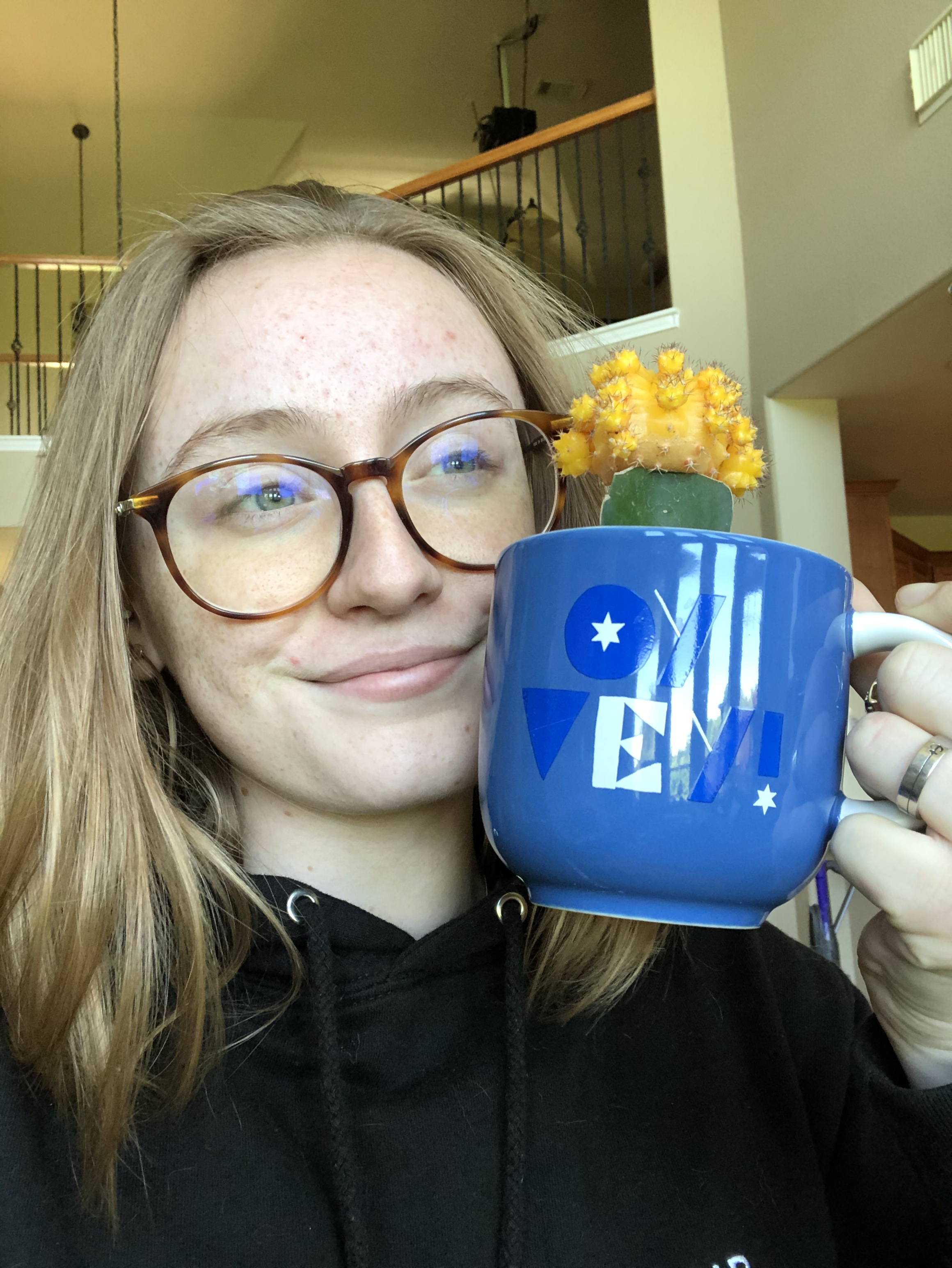 Selfie taken by Texas State student Sam Searles while holding a coffee mug with a cactus inside 