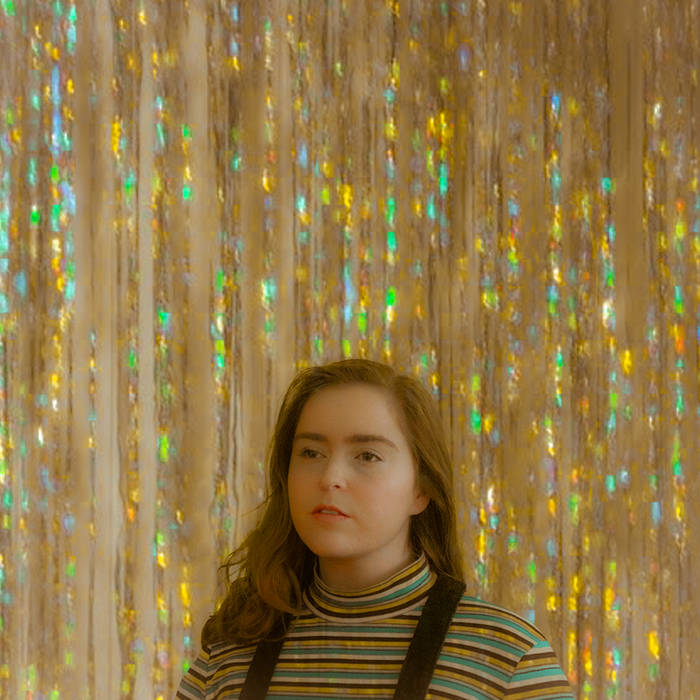 The album cover is a portrait of a young female in front of iridescent streamers.