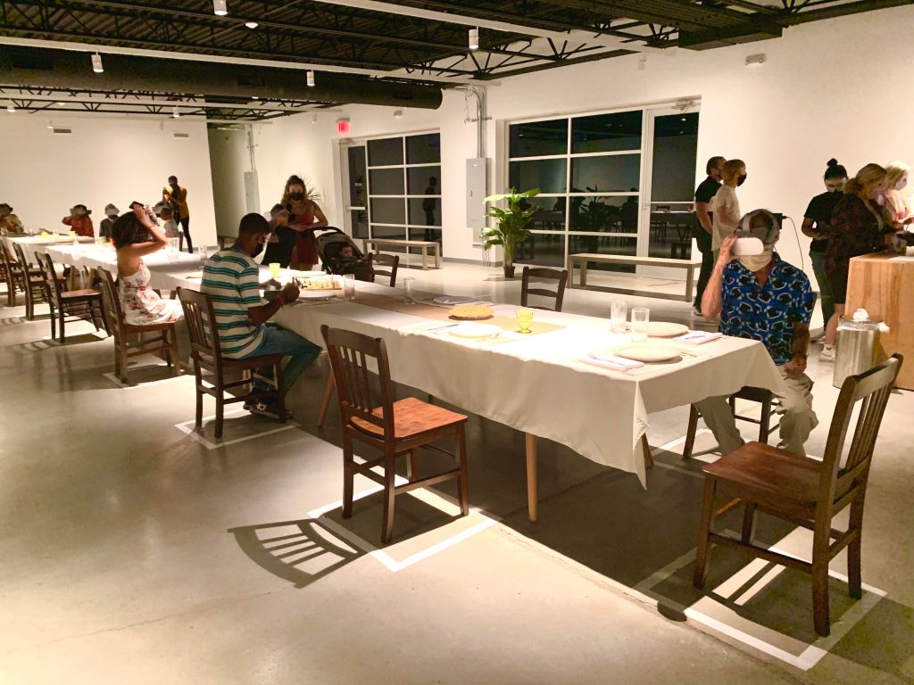 Visitors at Wonderspace sitting at a dinner table with VR headsets on 