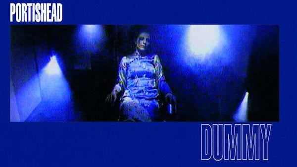 A solid blue background, fronted by a blurry image of a woman sitting under faint lights