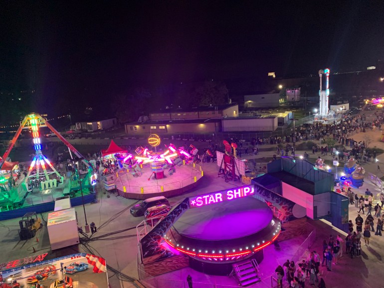 An overlook of the carnival rides from the top of the Ferris Wheel