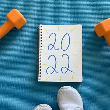 A blue floor with orange weights and a notebook with "2022" written on it