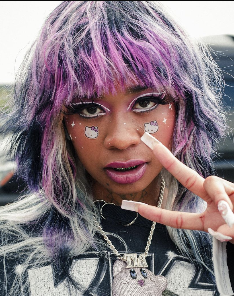 Close-up of Tia Corine throwing a peace Sign at Rolling Loud