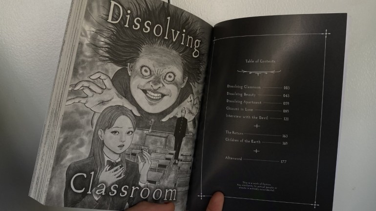 The volume is held open. Left-hand page features an illustration of the main characters of “Dissolving Classroom”. Chizumi looms, up and center, over a classroom setting as Yuuma is dwarfed on the right-hand side. One of their classmates wears a concerned expression on the bottom left.