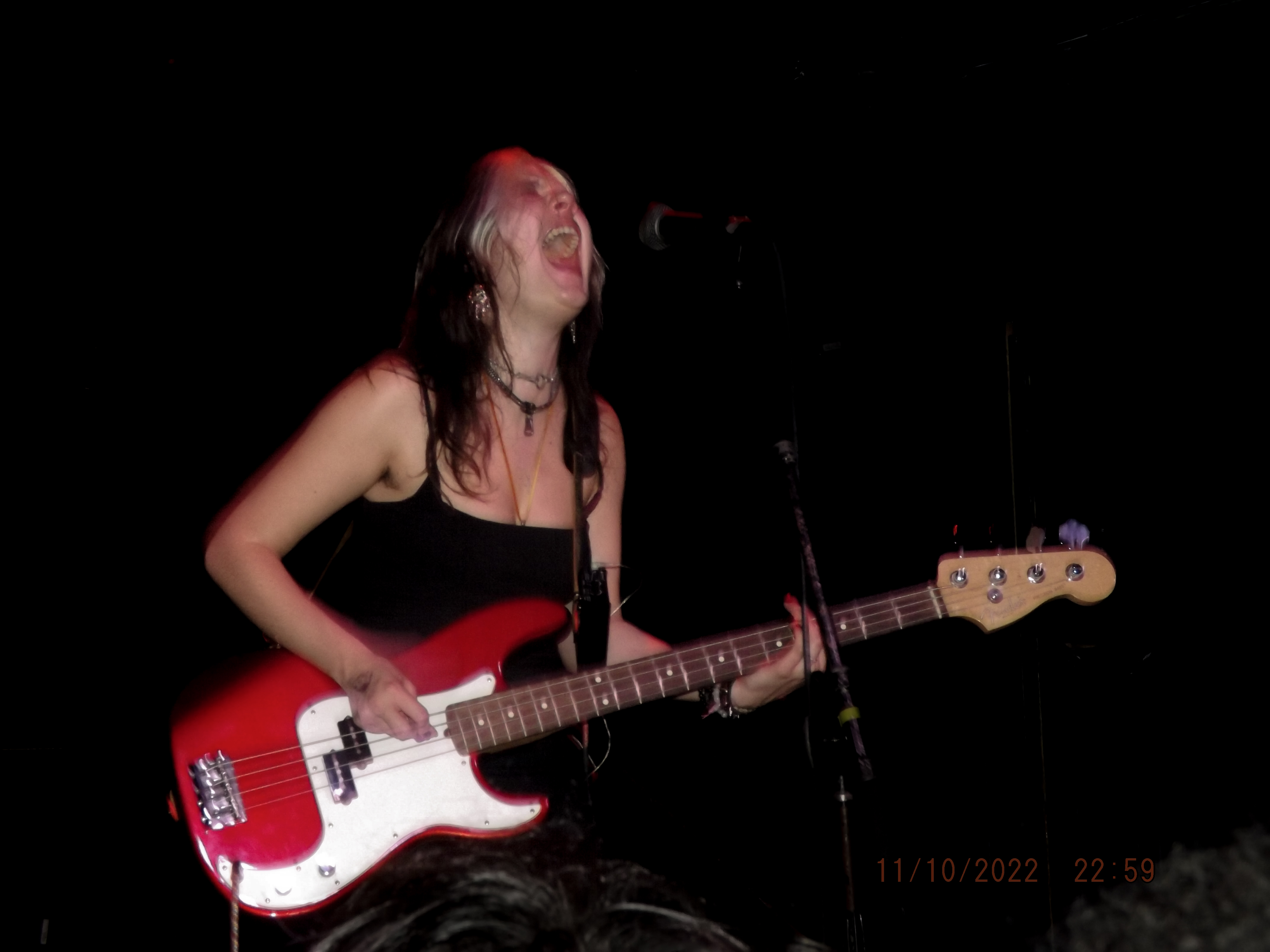 Sabrina Fuentes of Pretty Sick on a red bass guitar.