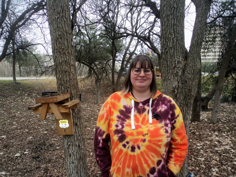 Luci, the Marketing Coordinator of the Student Health Center, immersed in some trees whilst wearing a tie-dye hoodie