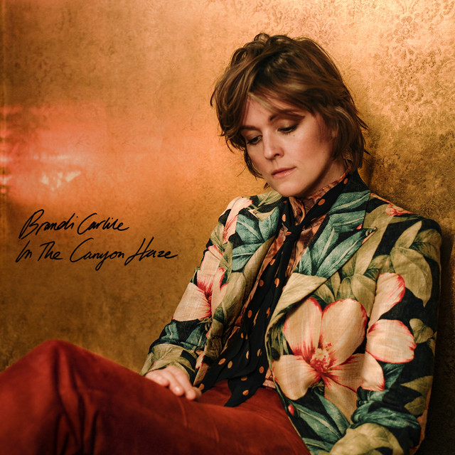 The album cover shows Carlile in a floral suit looking down at her leg. The Title of the album is to the left in black cursive