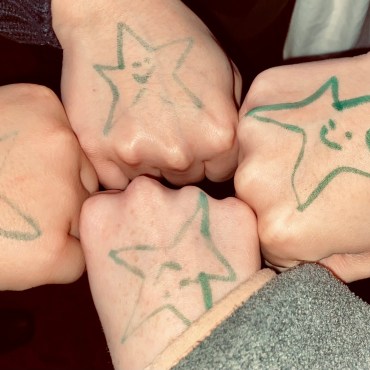 : four fists with green smiley face stars
