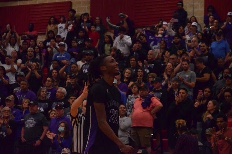 player in purple being cheered on by fans in purple 