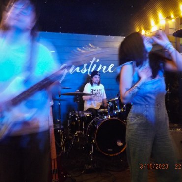 renforshort in blue jumpsuit afront drummer and guitarist