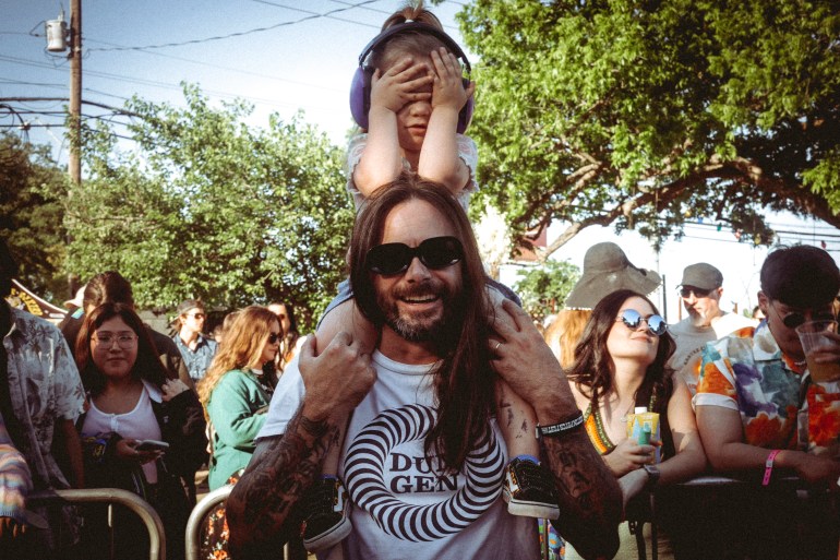 Father holds daughter on his shoulders at Austin Psych fest