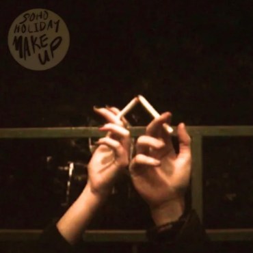The album cover features two hands holding a cigarette. The image looks like it might have been taken on a film camera.