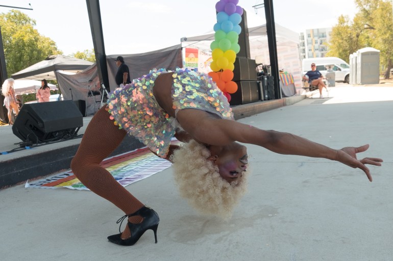 A drag queen in a back bend on stage