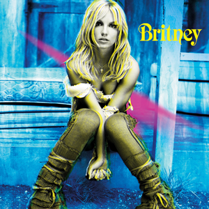 Britney Spears sits on a stoop with her arms between her knees.