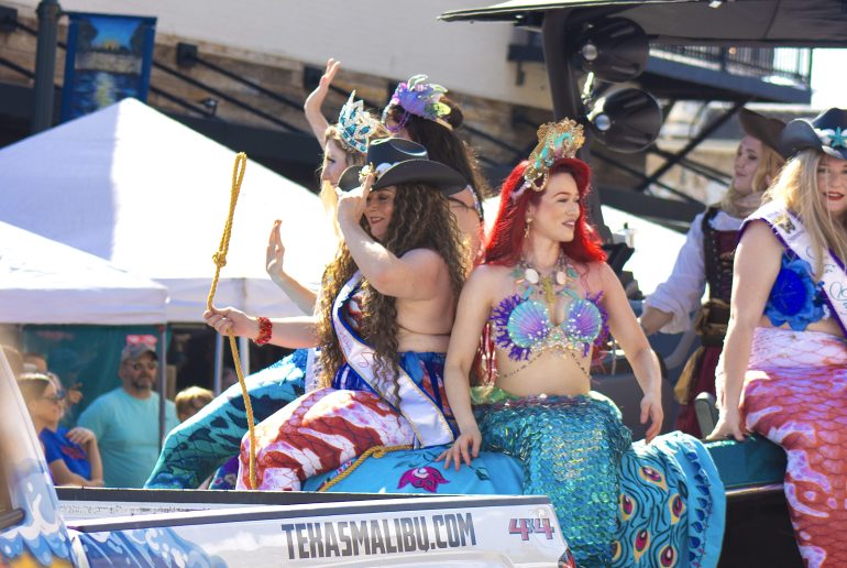 Mermaids sitting on top of a truck during the San Marcos mermaid festival