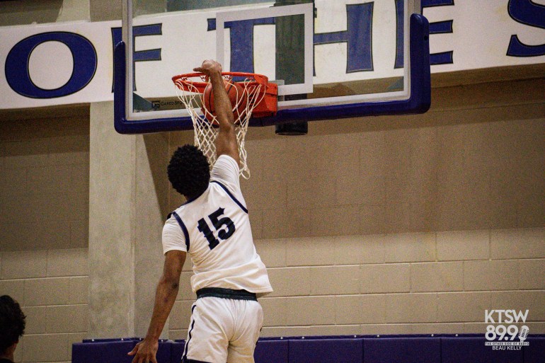 Article Name: The Rattlers Secure a Triumphant Win Over the Lockhart Lions 
Author(s): Grace Reddic

Photo Credits: Beau Kelly

Alt-text: Junior Josiah Hollmon dunks a shot at home in San Marcos to extend the Rattlers lead over the Lions.

Location: San Marcos High School Gymnasium (San Marcos, Texas)
