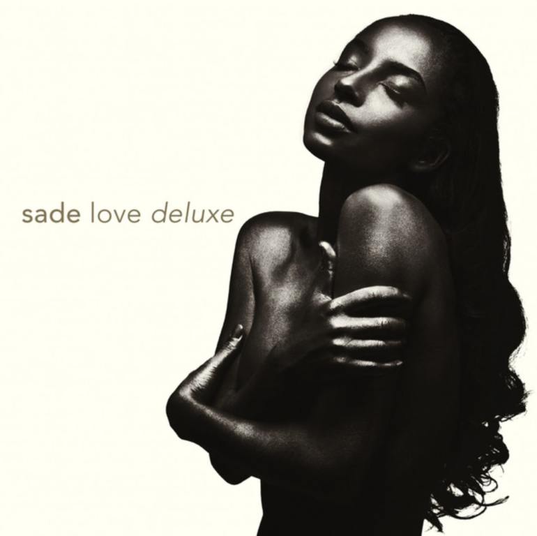 Sade upper body is positioned on the right side in front of a plain white background. She is naked and covering her chest, her head is held high with eyes closed and her hair flowing down. Her name and the title of the album are horizontal to the left of her.
