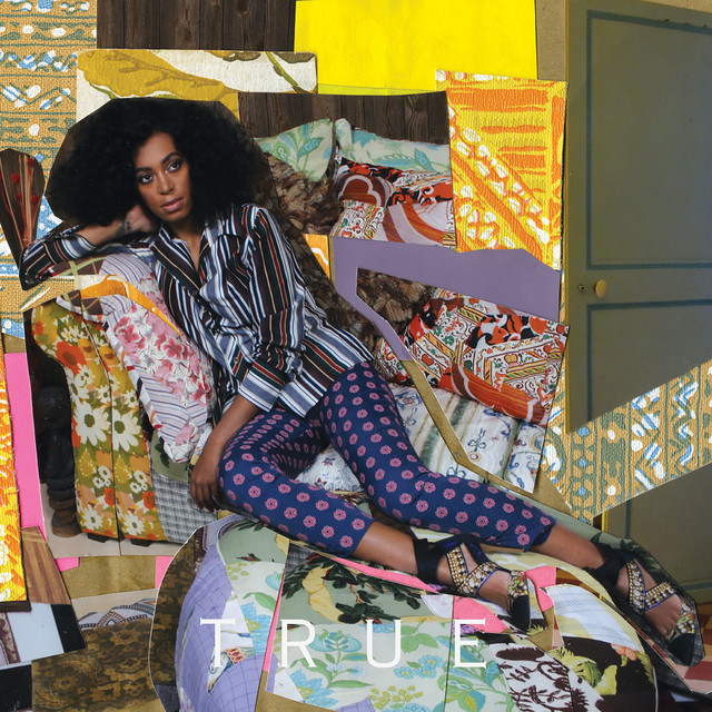 Solange on top of furniture with a clash of abstract shapes and colors with a solemn look