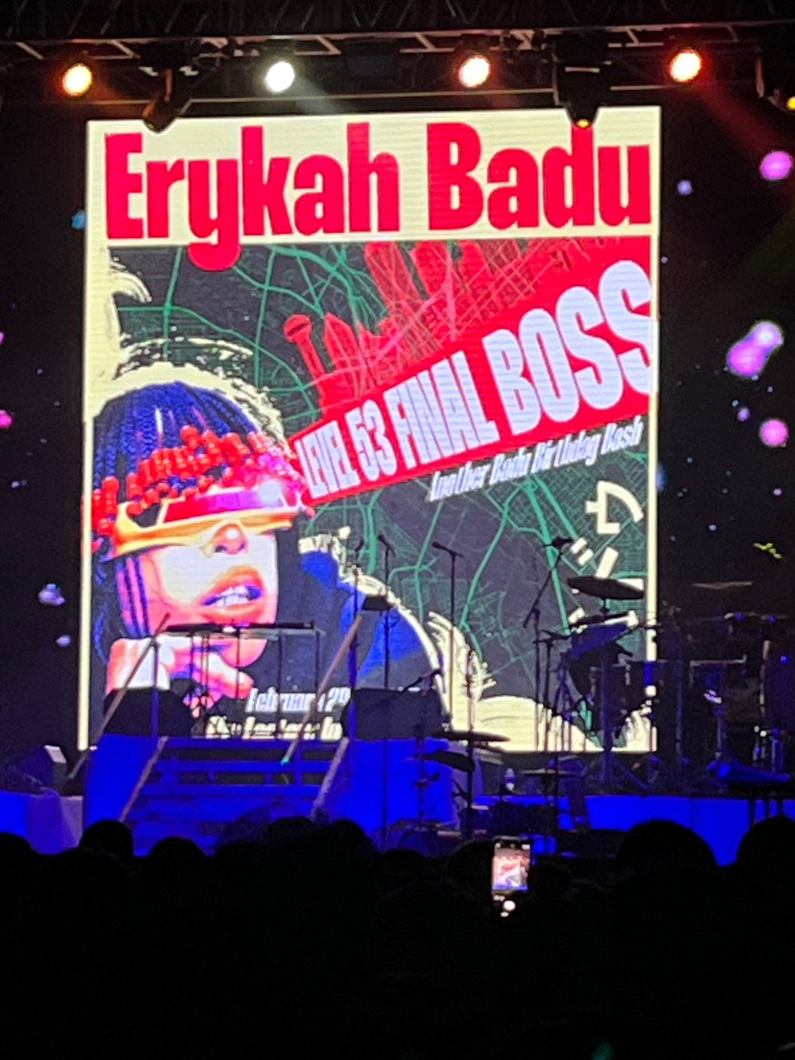 Picture taken at the concert of some of the cover art for the concert. Erykah Badu’s face and name promptly displayed in a pop artistic style. Level 53 final boss is in a red strip going through the picture horizontally until it reaches her face then stops.