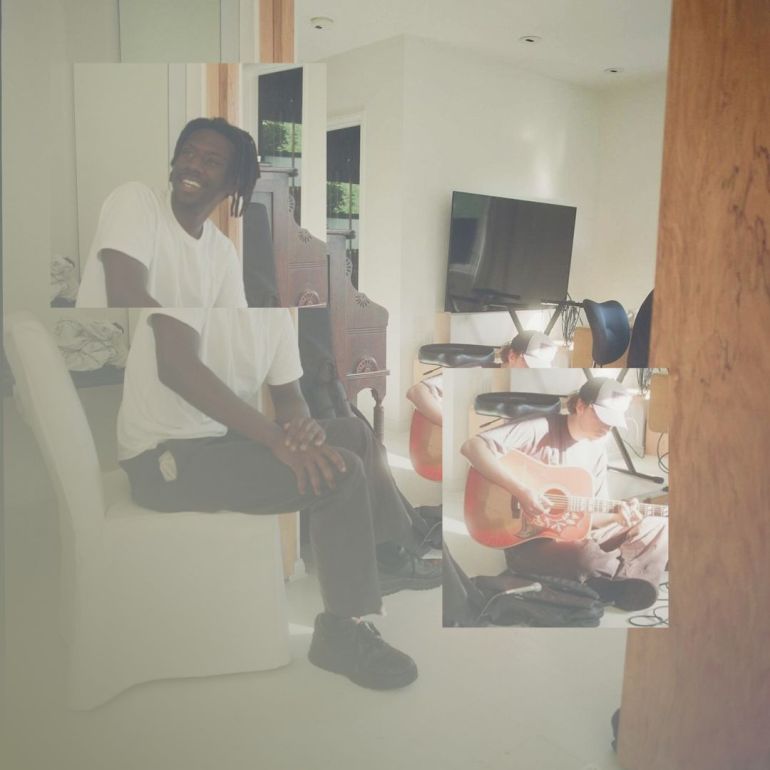 Photo of binki working on music in a studio with Billy Lemos and Chase Plato. He is wearing a plain white tee, black pants, and black shoes