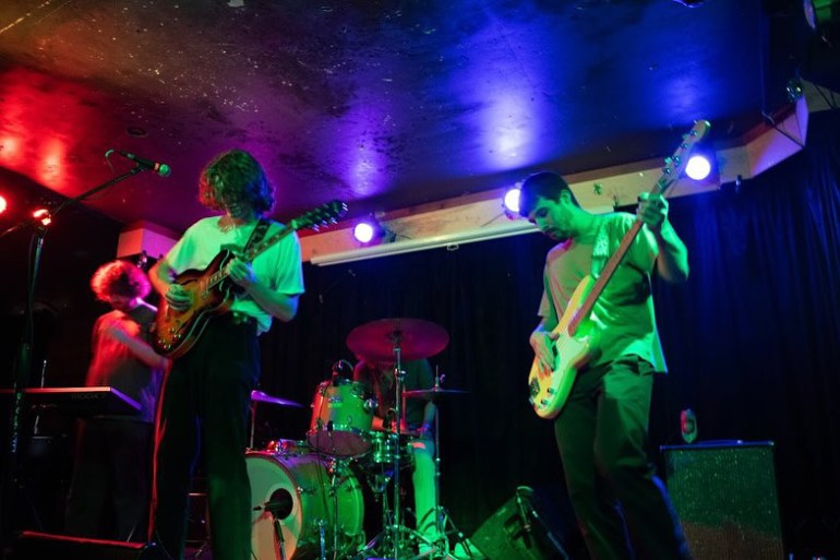 Band Members of Arbordae performing alongside each other in a colorful shade of coloring